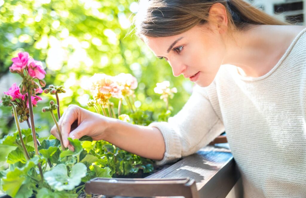 Woman Looking at Flower and Checking for pests-1