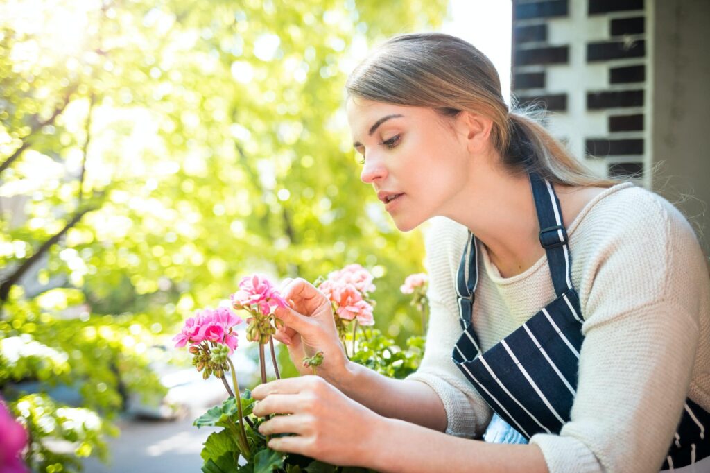 Woman Looking at Flower and Checking for pests